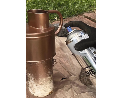 Een persoon spuit een kan met een spuitbus.