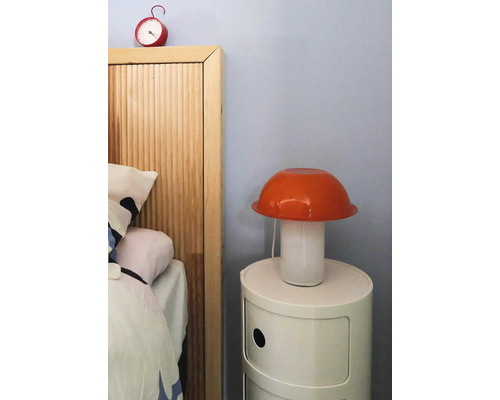 Slaapkamer met nachtkastje, lamp en wekker