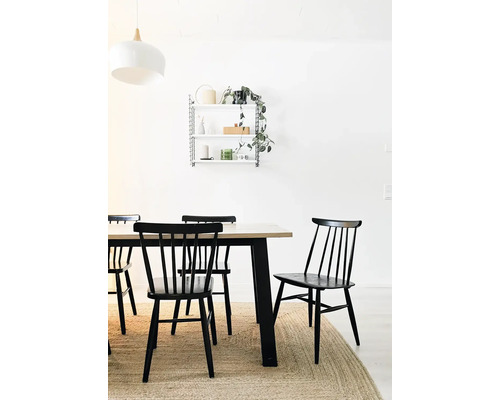 Eetkamer met houten tafel, zwarte stoelen en wandrek