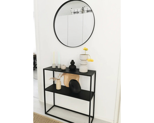 Console met twee planken met decoratie en een ronde spiegel aan de muur