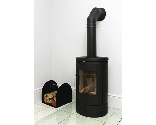 Zwarte houtkachel met hout en een houtmand in een heldere kamer.