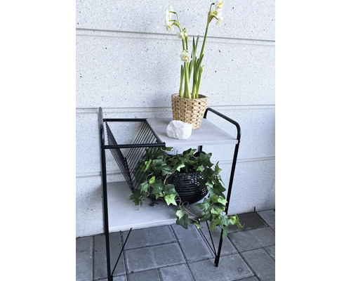 Decoratieve bijzettafel met twee planken, bloemdecoraties en tijdschriftencollectie voor binnenshuis.