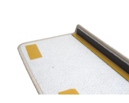 Detailopname van een trapmat van tapijt met plakstrips en hoek
