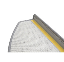 Detailopname van een grijze traptrede met textieloppervlak en plakstrips voor bevestiging.