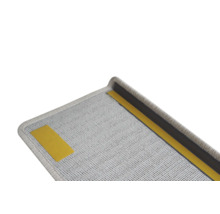 Detailopname van een grijze trapmat met plakstrip voor bevestiging.