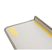 Detailweergave van een traptrede met tapijt en plakstrips voor bevestiging.