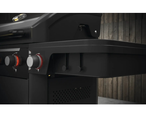 Detailopname van een zwarte gasbarbecue met bedieningsknoppen en zijtafel