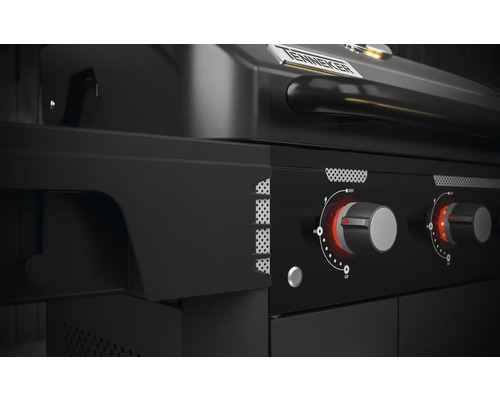 Detailopname van een zwarte gasbarbecue met draaiknoppen om de warmte te regelen