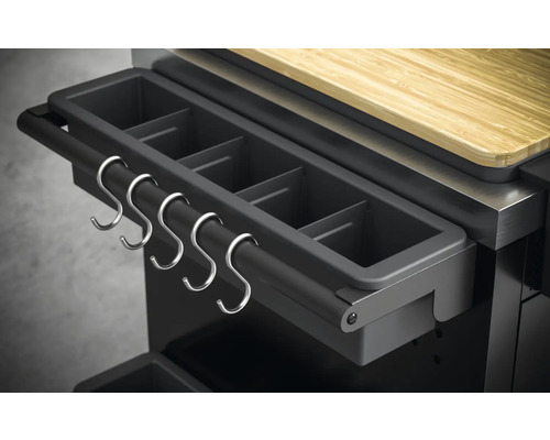 Detailopname van een buitenkeuken met bak voor barbecueaccessoires en metalen haken