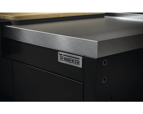 Detailopname van een zwarte werkplaatskast met roestvrijstalen werkblad en Tenneker logo