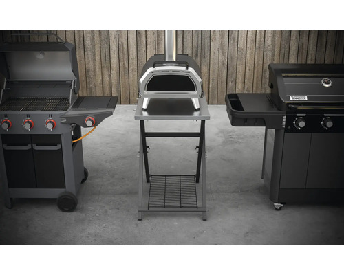 Drie verschillende barbecues in een buitenomgeving: gasbarbecue, pizzaoven en nog een barbecue.