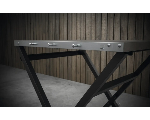 Gedetailleerd beeld van een inklapbare tafel met metalen frame en haken