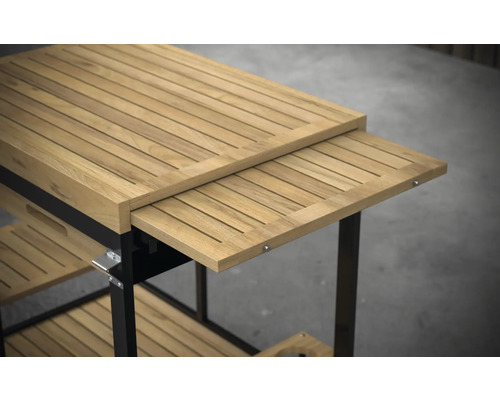 Gedetailleerde weergave van een serveerwagen van teakhout met uitschuifbaar werkblad en opbergvakken.