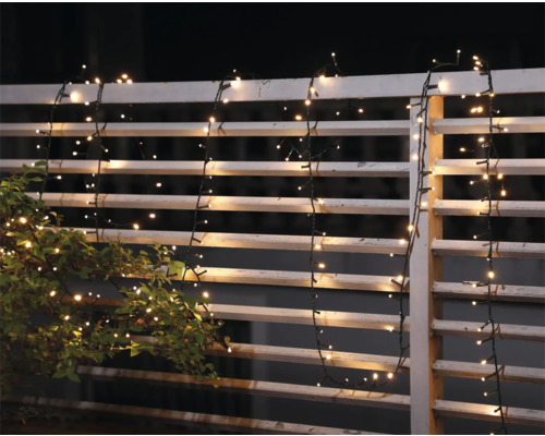 Decoratieve lichtslinger aan een tuinafsluiting