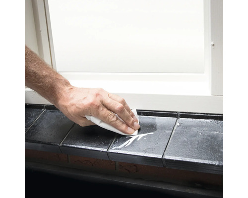 Reiniging van een vensterbank met een doek.