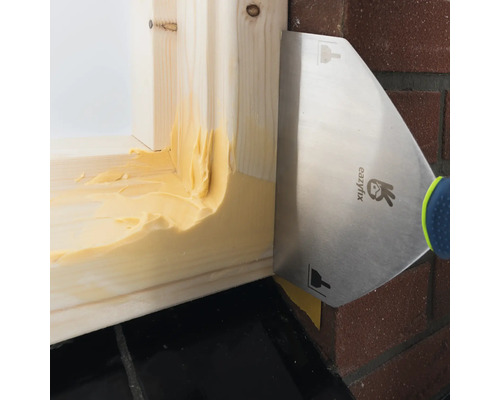 Aanbrengen van kit met een plamuurmes op een houten frame