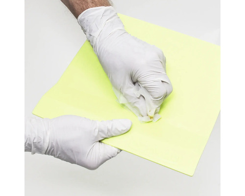 Handen met beschermende handschoenen reinigen een bouwplaat