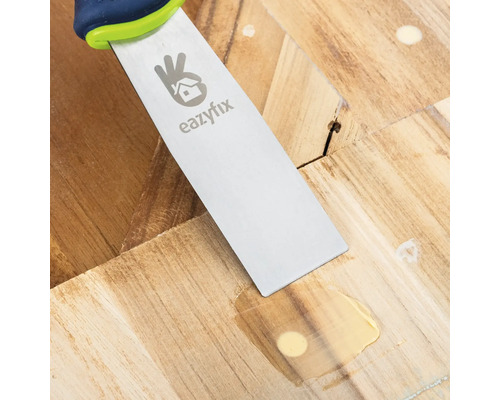 Plamuurmes bij het repareren van een houten vloer