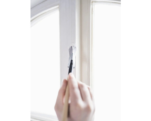 Hand schildert raamkozijn met penseel en verf