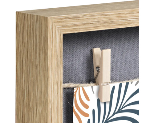 Detailopname van een houten fotolijst met wasknijper voor het ophangen van foto''s