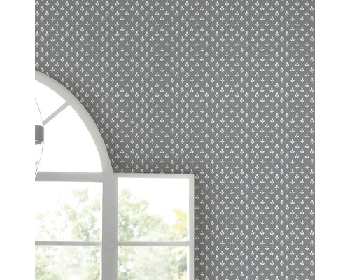 Muur met grijs behang en wit bladerpatroon naast raam