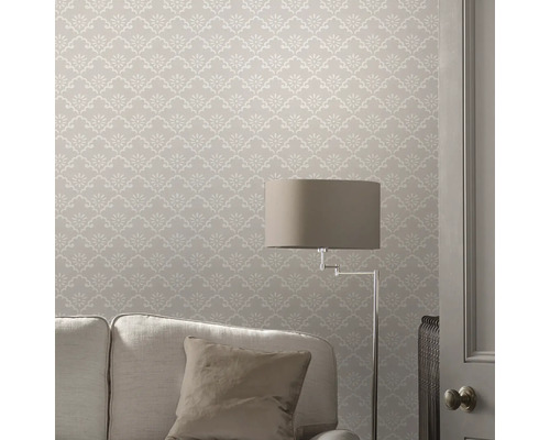 Woonkamer met patroonbehang, bank en staande lamp