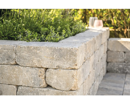 Muur van betonstenen beplant met planten