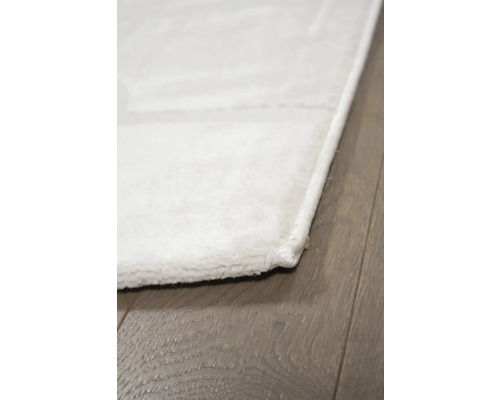 Detailopname van een wit tapijt op een houten vloer