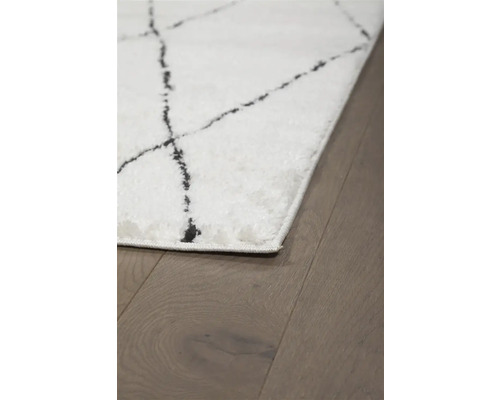 Wit tapijt met abstract patroon op houten vloer