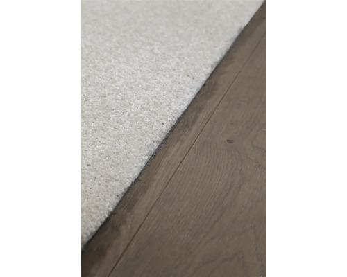 Detailopname van een lichtgekleurd tapijt op een houten vloer