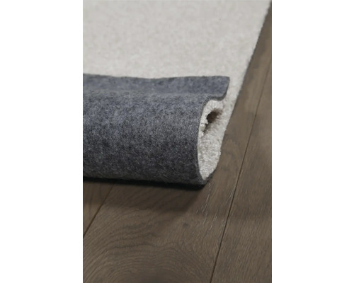 Detailaanzicht van een vloerkleed met textielrug op een houten vloer