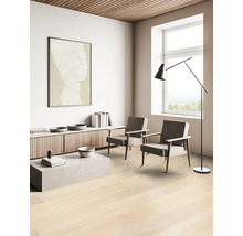 Lichte woonkamer met parketvloer, twee stoelen en minimalistische inrichting.