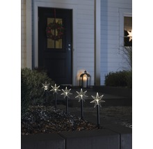 Decoratieve tuinverlichting met stermotieven voor een huis met een krans aan de deur