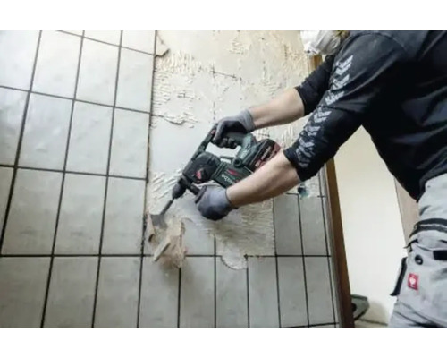 Een man verwijdert tegels met een breekhamer van Metabo