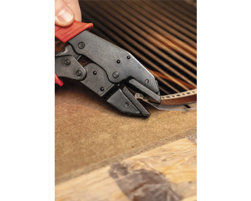 Persoon gebruikt een krimptang om een metalen strip vast te zetten