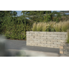 Tuinmuur van steen met beplanting voor een georganiseerde buitenruimte.