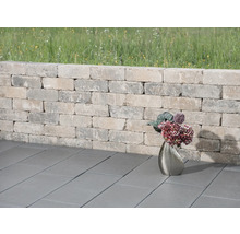 Tuinmuur van stenen met straatstenen en bloemenvaas