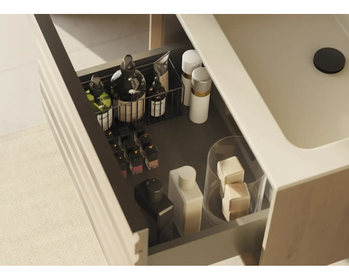 Open lade van een wastafelonderkast met diverse badkamerartikelen voor opslag