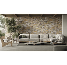 Woonkamer met hoekbank, salontafels en stenen muur