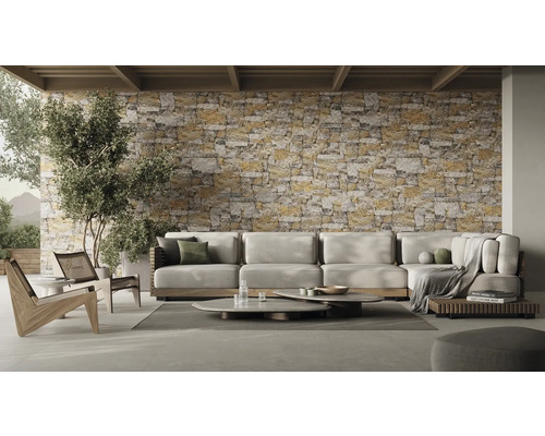 Woonkamer met hoekbank, salontafels en stenen muur