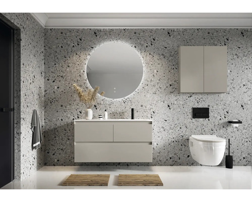 Moderne badkamer met wastafel, verlichte spiegel, hangkast en toilet tegen een wand met steenmotief