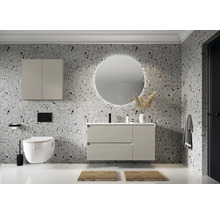 Moderne badkamer met wastafel, spiegelkast, toilet en ronde spiegel met verlichting tegen een gemêleerde wand