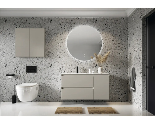 Moderne badkamer met wastafel, spiegelkast, toilet en ronde spiegel met verlichting tegen een gemêleerde wand