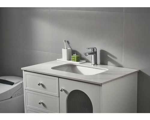 Wastafelmeubel met wastafel, kraan en badkameraccessoires voor een grijze muur