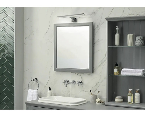 Badkamer met spiegel, wastafel, kraan en badkamerkast