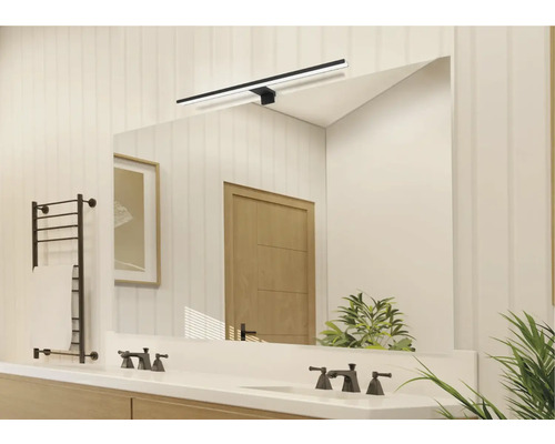 Lichte badkamer met spiegel, wastafel, kranen, handdoekradiator en verlichting