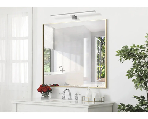 Vierkante spiegel met verlichting boven wastafel in badkamer.