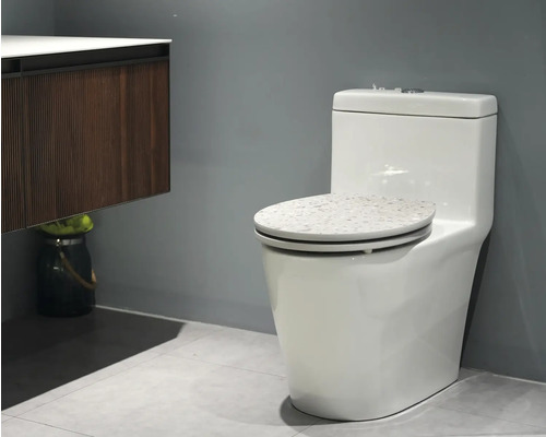 Wit staand toilet met reservoir en decor op de toiletbril in de badkamer.