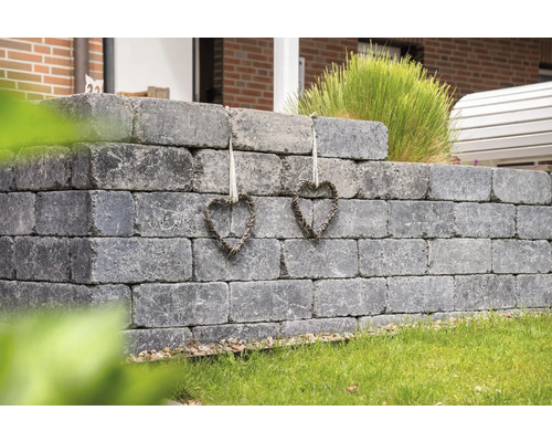 Grijze tuinmuur van betonstenen met twee hartdecoraties