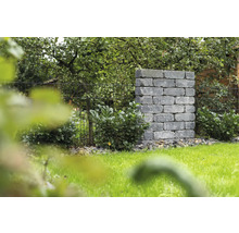 Landschapsbeeld met metselwerk van stenen blokken en metalen hek in de tuin